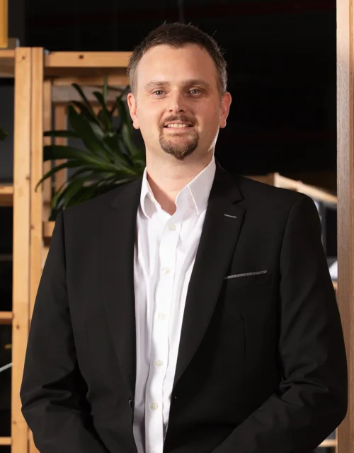 Gary Dodds standing in front a wall with an arabic ornament design in the Cundall Doha office