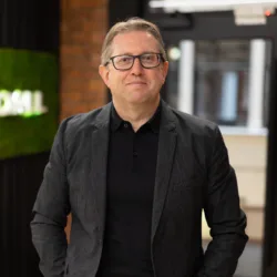 Andrew Bissell in the office with black wooden interior background