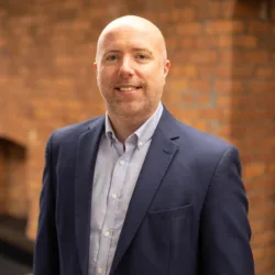 Darren Wood in office with brick background
