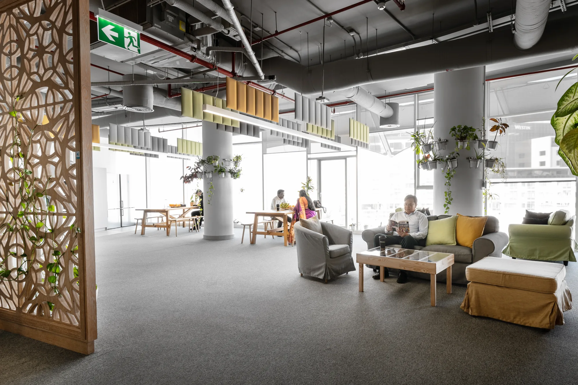 Cundall Qatar office break area with comfortable sofas and wooden dining tables